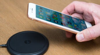 Hand legt iPhone 8 Plus auf Ladestation