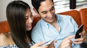 Paar schaut sich ein iPhone an.