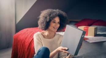 frau öffnet ihr paket von vodafone und nimmt den Kabel-router raus