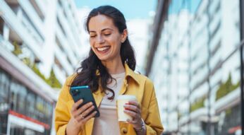 Lächelnde Frau passt auf iPhone die E-Mail-Adresse ihres Apple Accounts an