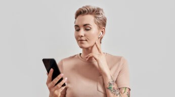 Frau mit Smartphone und AirPods-Kopfhörern