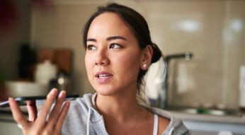 Frau gibt einen Sprachbefehl via Smartphone