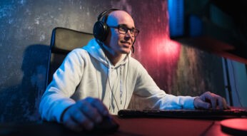 Mann mit Gaming-Headset sitzt am Computer