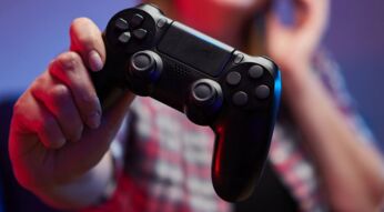 Frau hält PS4-Controller in der Hand.