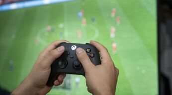 Ein Mann hält den Xbox-Controller in der Hand.