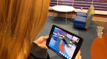 Eine Frau benutzt die AR-App MRI with Choco mit dem AR-Bär Choco