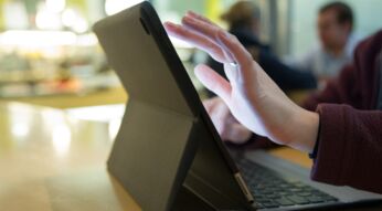 Frauenhände tippen auf iPad mit Tastatur