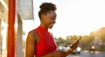 Frau mit Smartphone nutzt CallProtect, um Spam-Anrufe zu erkennen.