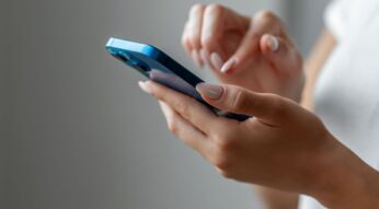 Frau hält iPhone in der Hand