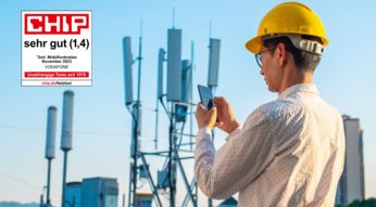Ein Mann steht mit einem Smartphone und einem Bauarbeiterhelm vor einem Funkmast und prüft seine Verbindung. Ein Chip-Testsiegel ist im linken Bildbereich zu sehen mit der Gesamtnote "sehr gut"