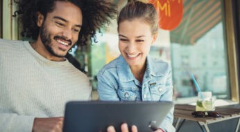 Frau schaut auf das Tablet von einem Mann