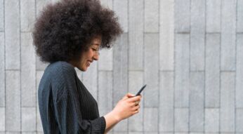 Eine junge Frau schaut auf ihr Smartphone