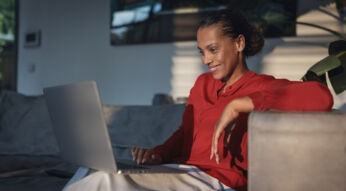 frau surft zuhause mit laptop im internet