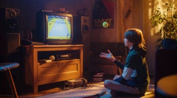 Ein Junge schaut gespannt einen Sport-Moment der TV-Geschichte