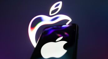 iPhone wird vor eine Leinwand mit Apple-Symbol gehalten