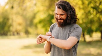 Junger Mann tipps draußen auf seine Smartwatch