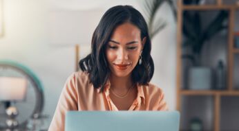 Frau liest ein E-Book auf dem Laptop.