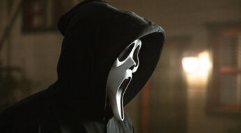 Auf dem Bild zu Scream 7 ist der ikonische Killer Ghost Face zu sehen. Er trägt eine schwarze Kapuze und die bekannte weiße Maske mit weit aufgerissenem Mund und leeren Augen. Die Szene wirkt düster und unheimlich, mit verschwommenen Lichtern im Hintergrund, die eine bedrohliche Atmosphäre erzeugen