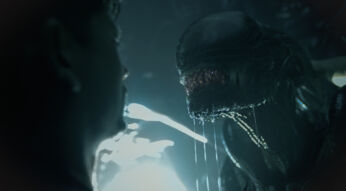 Auf dem Bild zu Alien: Romulus steht eine Person in angespannter Konfrontation mit einem Xenomorph. Das ikonische Alien, mit glänzendem, biomechanischem Kopf und tropfendem Speichel, nähert sich bedrohlich. Die dunkle, neblige Atmosphäre und das kalte Licht im Hintergrund verstärken die Spannung. Die angedeutete Silhouette der Person unterstreicht die Gefahr und das Gefühl von Ausweglosigkeit in dieser intensiven Szene.