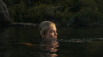 Charlize Theron schwimmt im Fluss in einer Szene des Netflix-Films "Apex"