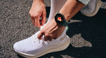 Mann mit Galaxy Watch am Arm bindet seine Schuhe zu.