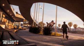 Auf dem Bild in dem Artikel zu den Tony Hawk’s Pro Skater 3 + 4 Tipps steht ein Skater mit Skateboard in der Hand in einem sonnigen Skatepark. Im Hintergrund sind Palmen, moderne Architektur und eine große Halfpipe zu sehen.