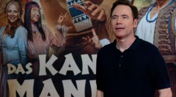 Michael Bully Herbig steht vor einem Poster seines Films "Kanu des Manitu"