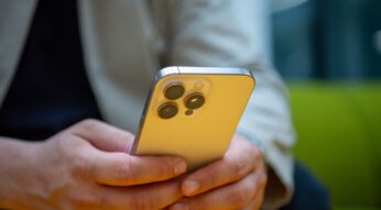 Ein Mann hält ein iPhone in den Händen.