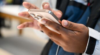 Eine Person hält ein iPhone in der Hand.