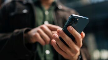 Mann tippt auf ein iPhone.