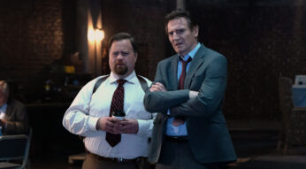 In den GigaTV-Highlights im Oktober 2025 siehst du eine Szene aus dem Film „Die nackte Kanone“, in der Liam Neeson als Frank Drebin Jr. und Paul Walter Hauser als Ed Hocken Jr. nebeneinander stehen. Beide blicken ernst und leicht verwirrt nach vorne.