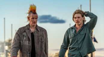 Auf dem Bild in den GigaTV-Highlights im November 2025 siehst Du eine Szene aus dem Film „Caught Stealing“. Austin Butler und Matt Smith laufen nebeneinander. Smith trägt eine auffällige Jacke mit Punk-Schriftzügen und einen orange-gelben Irokesenhaarschnitt, während Butler ein grünes Hemd trägt und sich mit der Hand durch die Haare fährt.