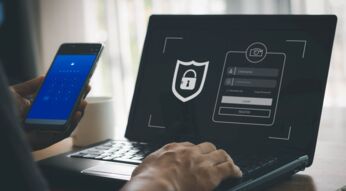 Ein Mann tippt Passwort und E-Mail-Adresse am Laptop ein.