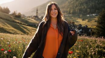 Simone Thomalla posiert für die Kamera auf einer Wiese.