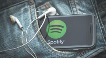 Ein Smartphone mit Spotify steckt in der Hosentasche einer Jeans.