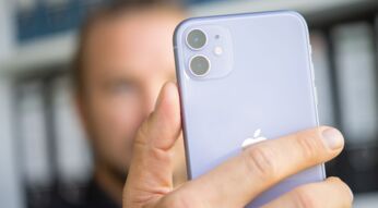 Mann hält das iPhone 11 Pro vor sein Gesicht.