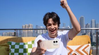 Junger Mann schaut lachend auf sein Redmi-Note-17-Handy.
