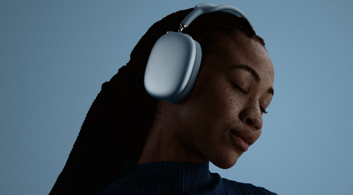 Ein junge Frau trägt AirPods Max 2 und hält dabei die Augen geschlossen.