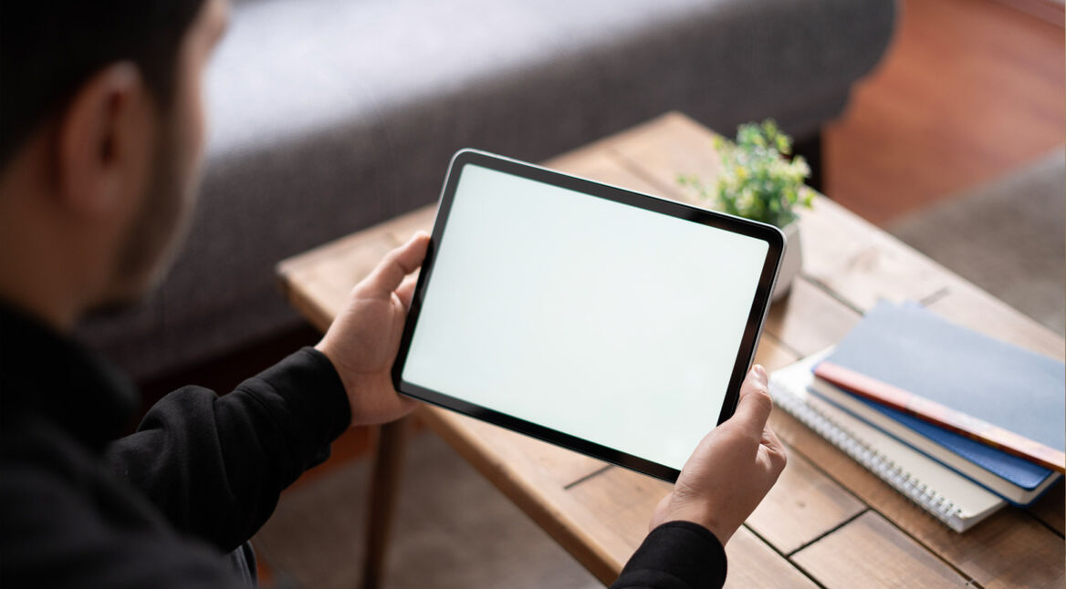 Ein Mann hält ein Tablet in seinen Händen