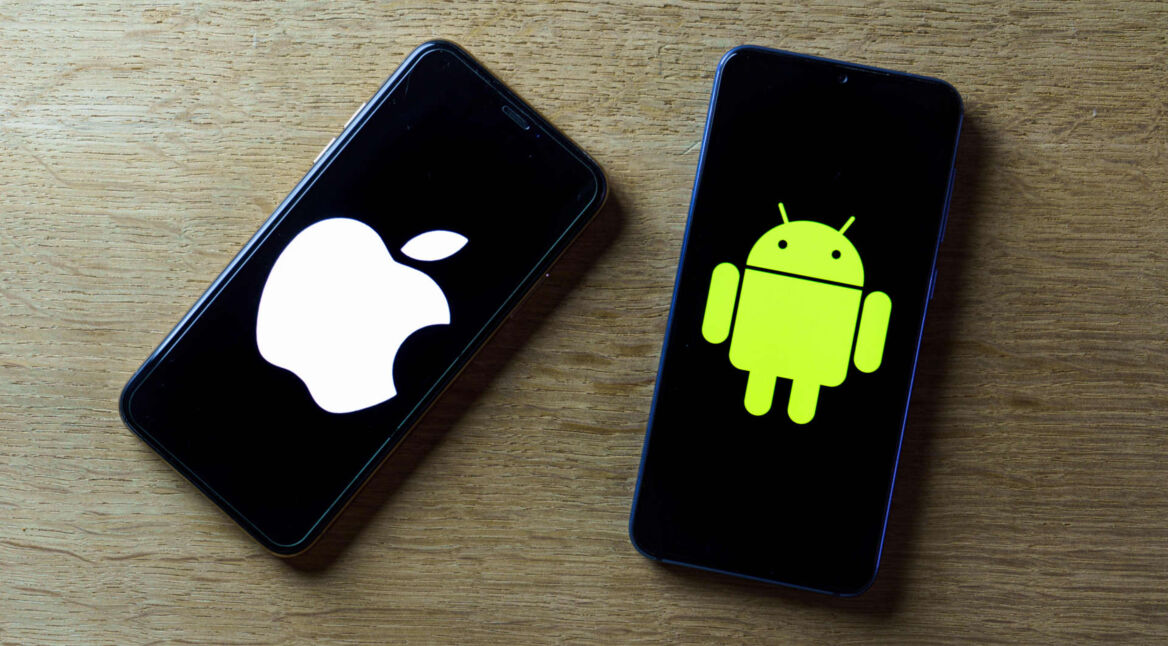 Zwei Smartphones liegen nebeneinander. Auf einem das Apple-Logo, auf dem anderen das Android-Maskottchen.