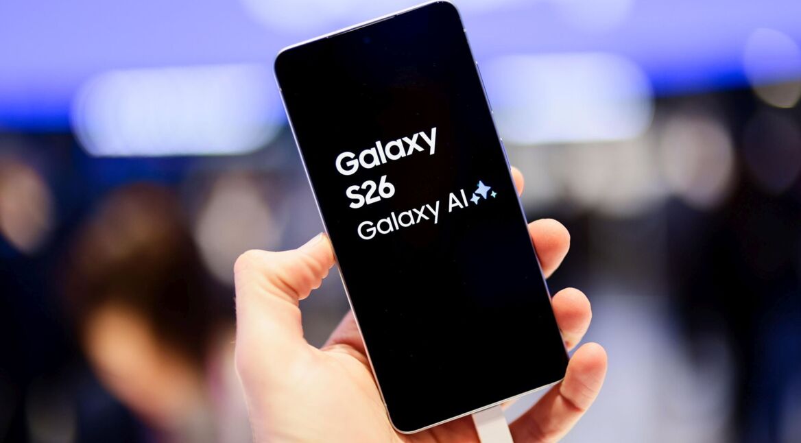 Besucher auf dem Mobile World Congress 2026 hält das Samsung-Handy Galaxy S26 hoch.
