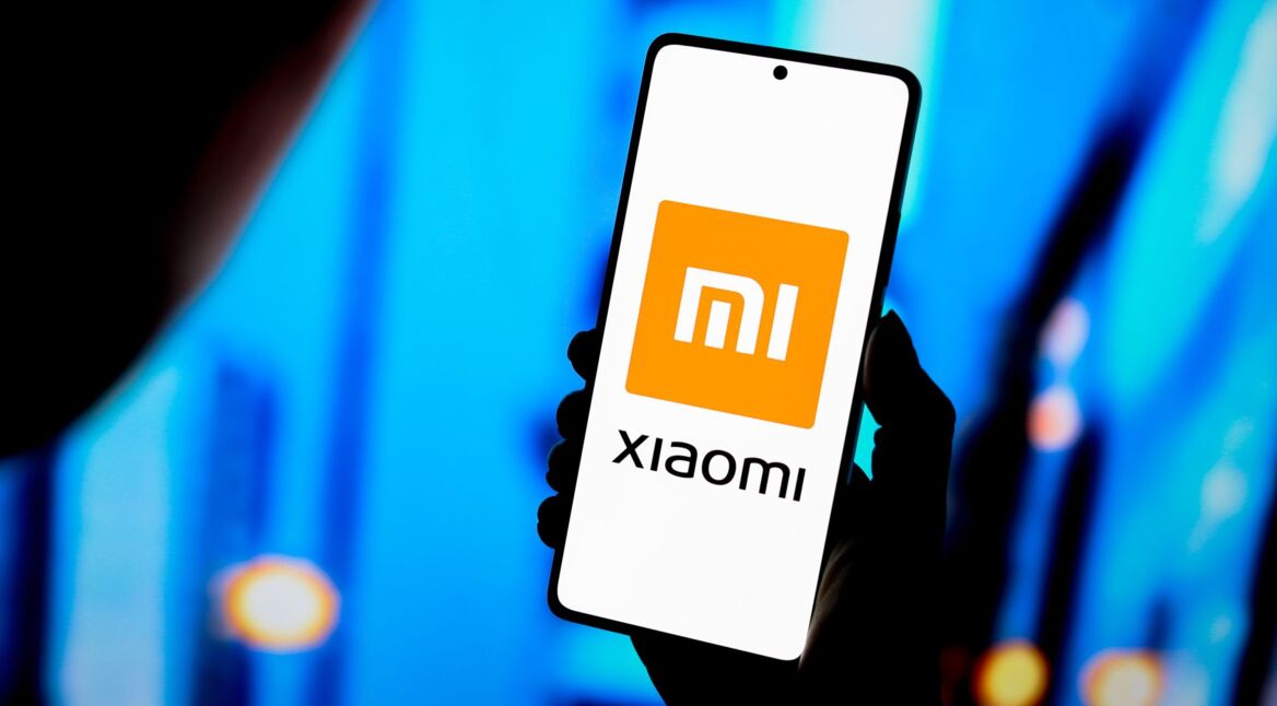 Person hält Android-Handy mit dem Xiaomi-Logo auf dem Display hoch.