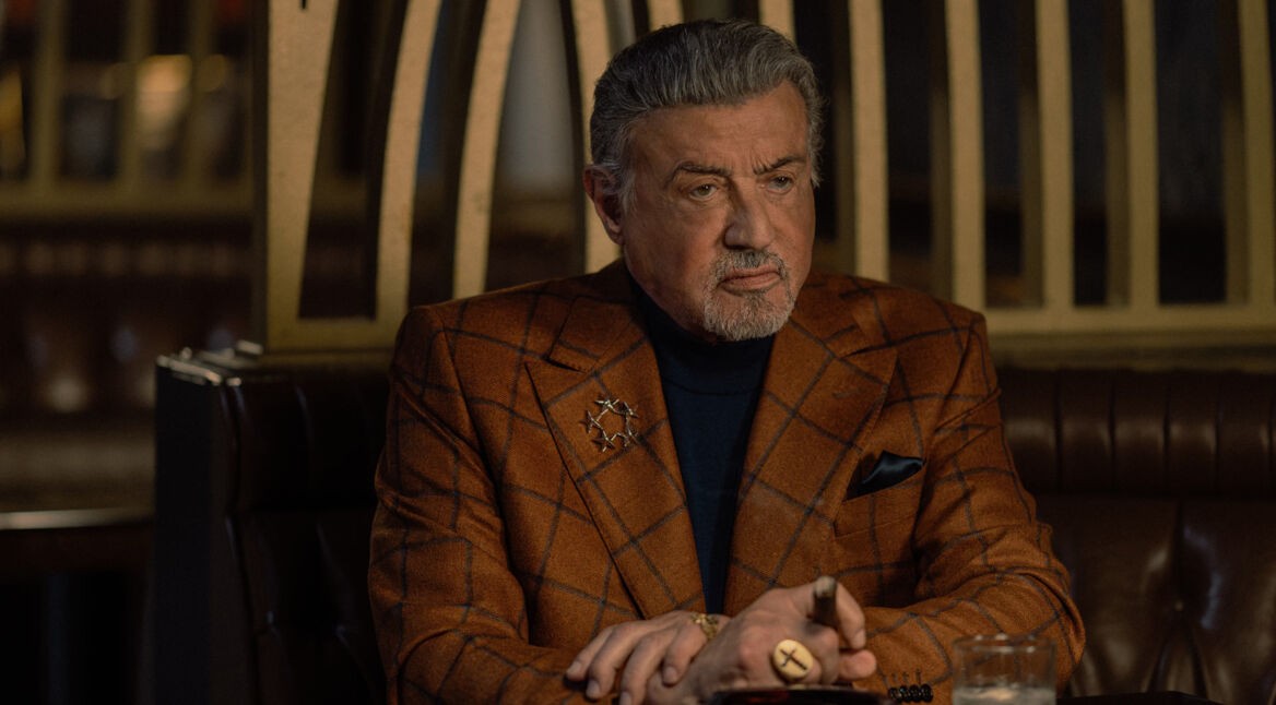 Sylvester Stallone sitzt als Dwight Manfredi in „Tulsa King“ Staffel 4, neu auf Paramount+, mit Zigarre in einer Bar
