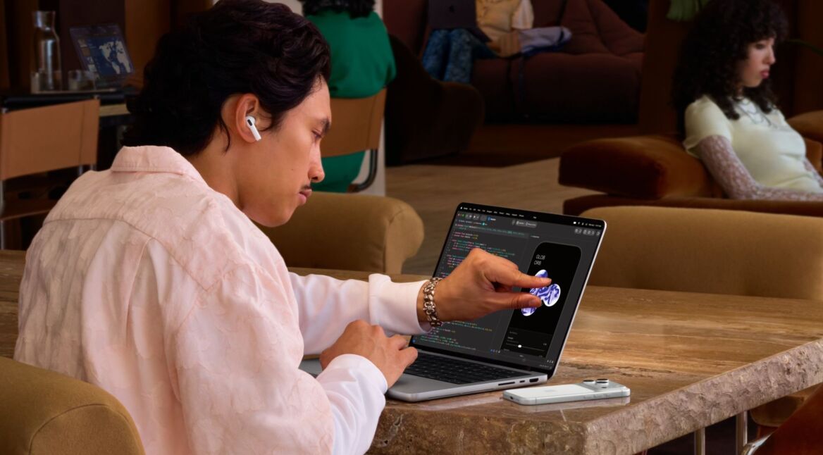 Junger Mann arbeitet am Touchscreen des MacBook Pro.