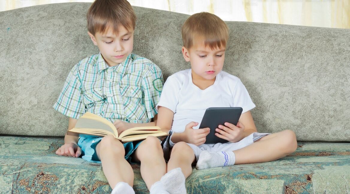 Two reading boys. With paper and electronic book