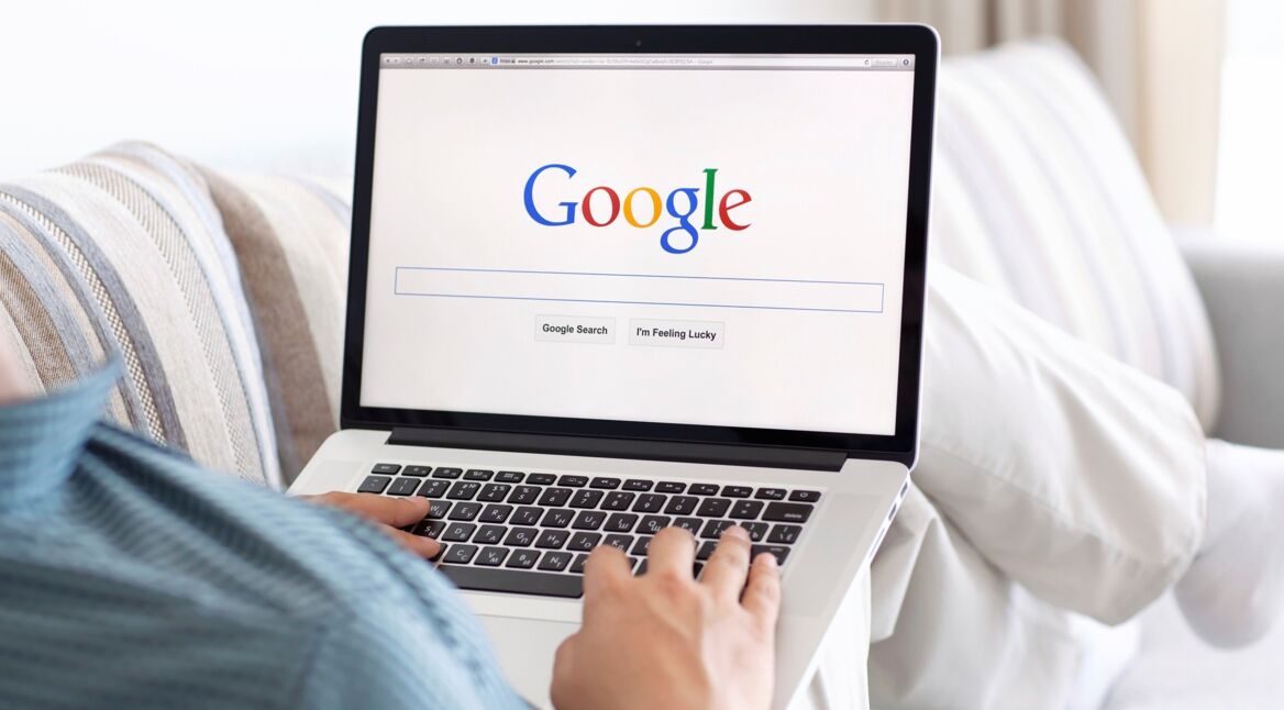 man sitting at the MacBook retina with site Google on the screen