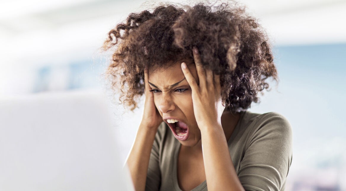 Angry African American woman using computer.