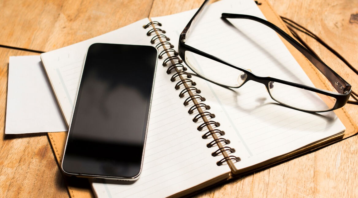blank cell phone diary and glasses