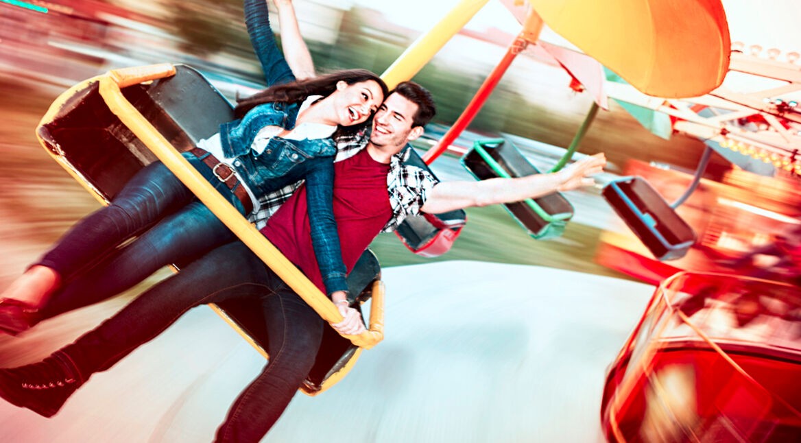 Young happy couple having fun at amusement park