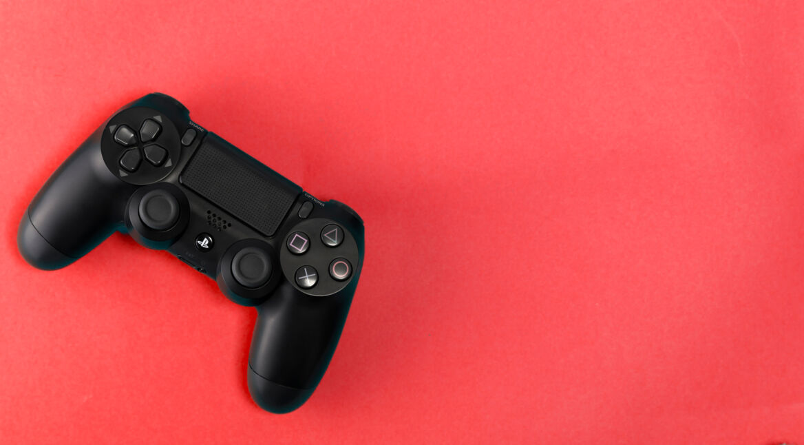 Sony PlayStation 4 Slim 1Tb revision and game controller on blue background